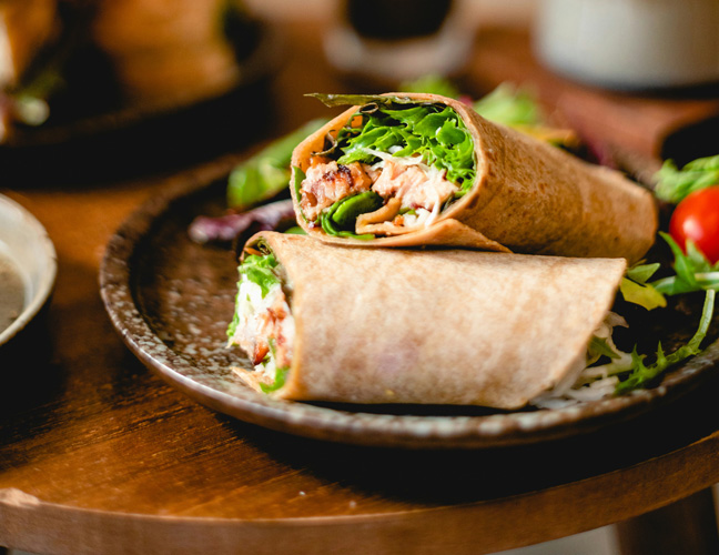 Ízletes félbevágott burrito egy vágódeszkán