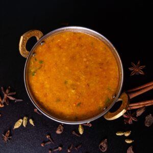 Vöröslencsés dal különböző fűszerekkel körbedíszítve.