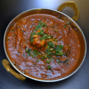 Lazacos curry, korianderrel díszítve, egy hagyományos indiai tálkában tálalva